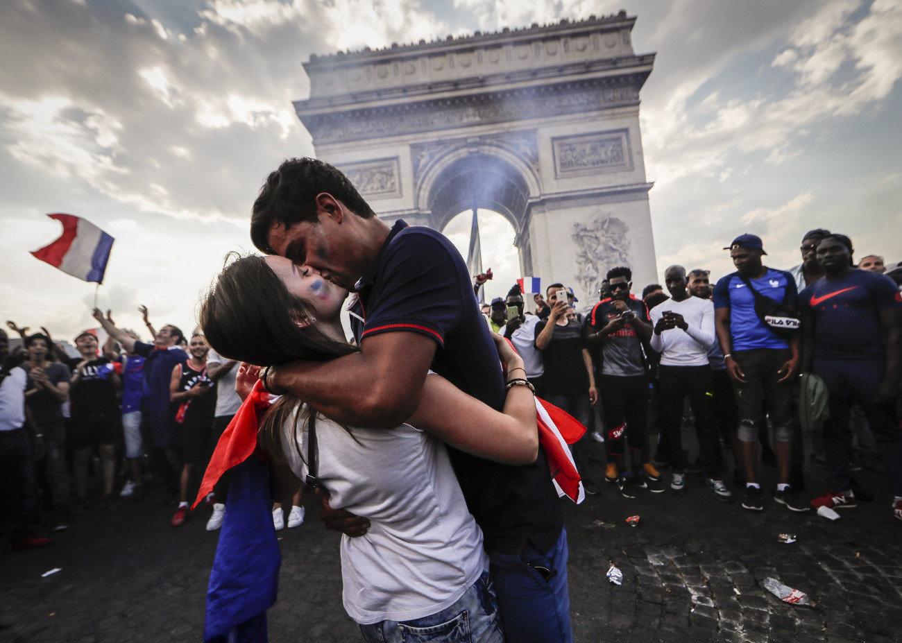 A francia válogatott diadalát ünneplő emberek a párizsi Champs-Élyées-n 2018. július 16-án. Franciaország az előző este 4-2-re győzött Horvátország ellen az oroszországi labdarúgó-világbajnokság döntőjében. A háttérben a diadalív látható. (MTI/EPA/Ian Langsdon)