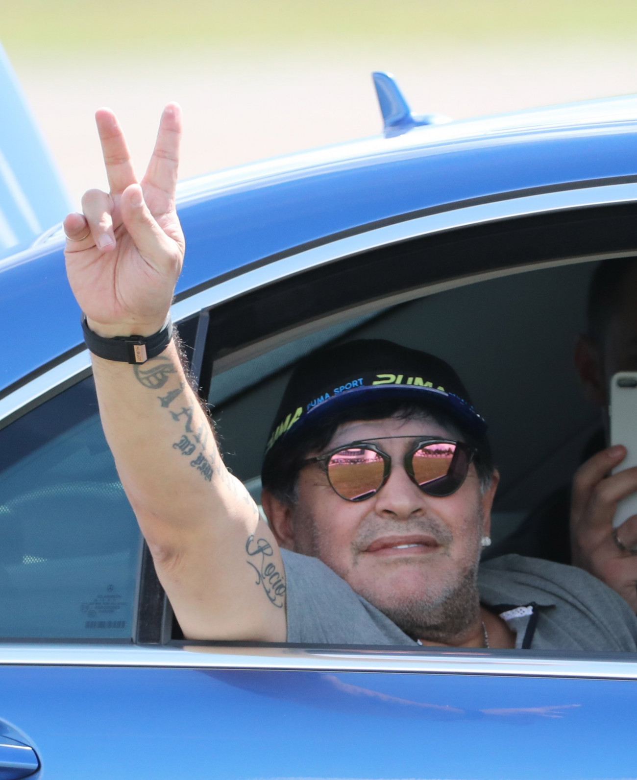 Breszt, 2018. július 16.
Diego Maradona egykori argentin válogatott labdarúgó int egy autóból, miután megérkezett a fehéroroszországi Breszt nemzetközi repülőterére 2018. július 16-án. Az 57 éves legendás futballista ezen a napon három évre szóló szerződést írt alá, amellyel a fehérorosz élvonalban szereplő Dinama Breszt labdarúgóklub elnökévé vált. (MTI/EPA/Taccjana Zenkovics)