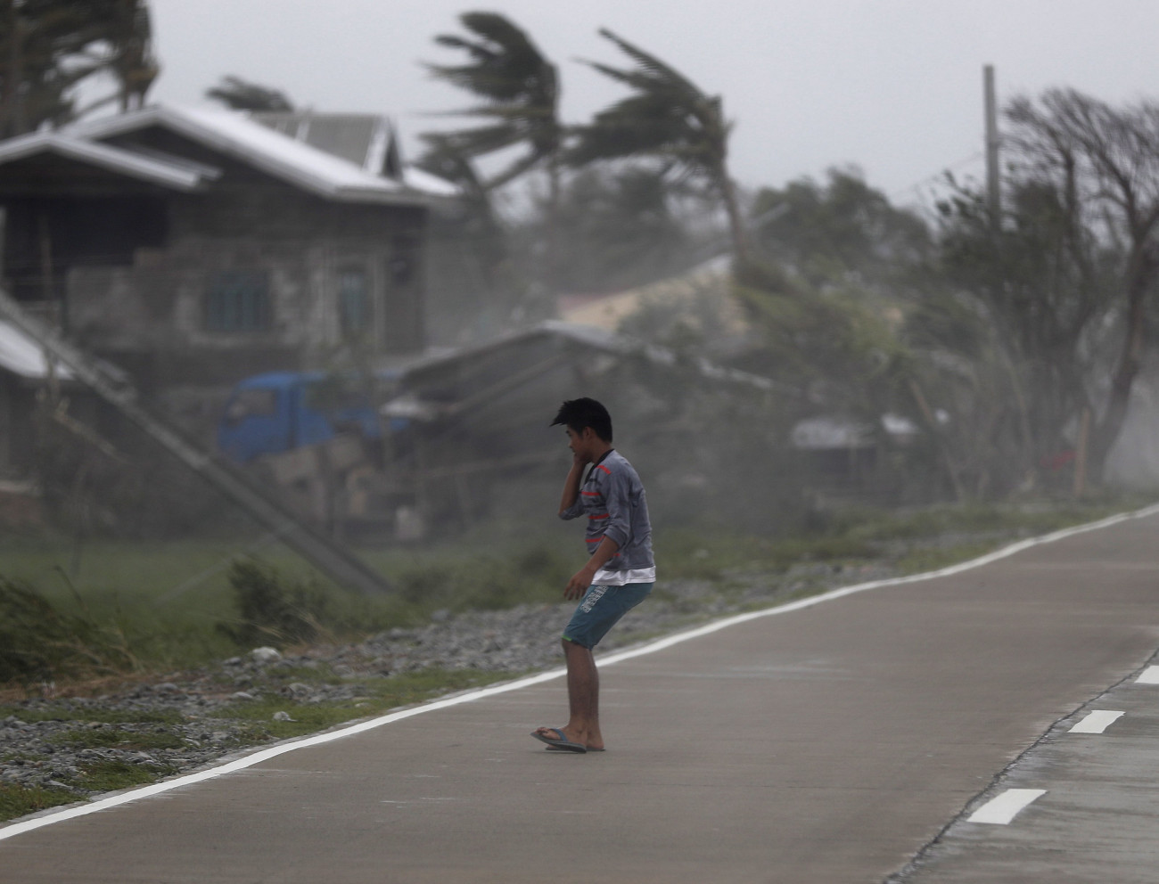 Férfi a Mangkhut tájfun által okozott viharos szélben a Fülöp-szigeteki Baggaóban 2018. szeptember 16-án. A természeti csapás legkevesebb huszonöt halálos áldozatot követelt, több mint százezer embernek kellett elhagynia othonát. (MTI/EPA/Francis R. Malasig)