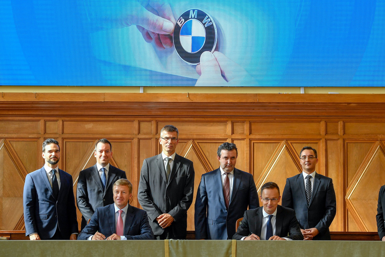 Debrecen, 2018. október 12.
Oliver Zipse, a BMW Group igazgatótanácsának gyártásért felelős tagja (elöl b) és Szijjártó Péter külgazdasági és külügyminiszter (elöl j) a BMW debreceni gyárberuházásának támogatásáról szóló megállapodást a Debreceni Egyetemen 2018. október 12-én. Mögöttük Barcsa Lajos (Fidesz-KDNP) alpolgármester, Ésik Róbert, a Nemzeti Befektetési Ügynökség (HIPA) elnöke, Michele Melchiorre, a BMW gyár debreceni igazgatója, Palkovics László innovációs és technológiai miniszter és Papp László (Fidesz-KDNP) polgármester (b-j).
MTI Fotó: Czeglédi Zsolt