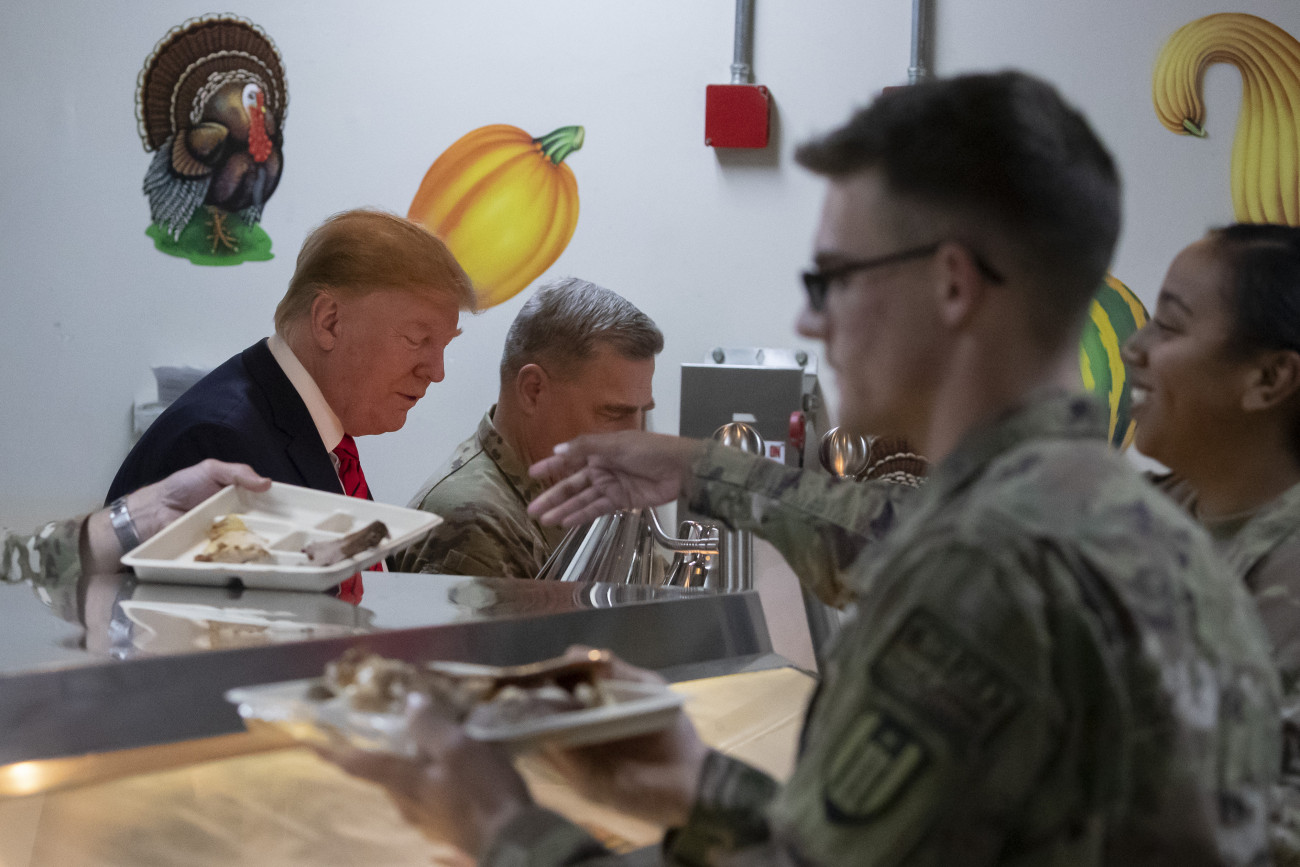 Donald Trump amerikai elnök (b) Mark Milley tábornoknak, a vezérkari főnökök egysített bizottsága elnökének (b2) társaságában vacsorát oszt a bagrami légi támaszponton szolgáló amerikai katonáknak, akiket a hálaadás ünnepének alkalmából keresett fel meglepetésszerű afganisztáni látogatása alatt, 2019. november 28-án.
MTI/AP/Alex Brandon