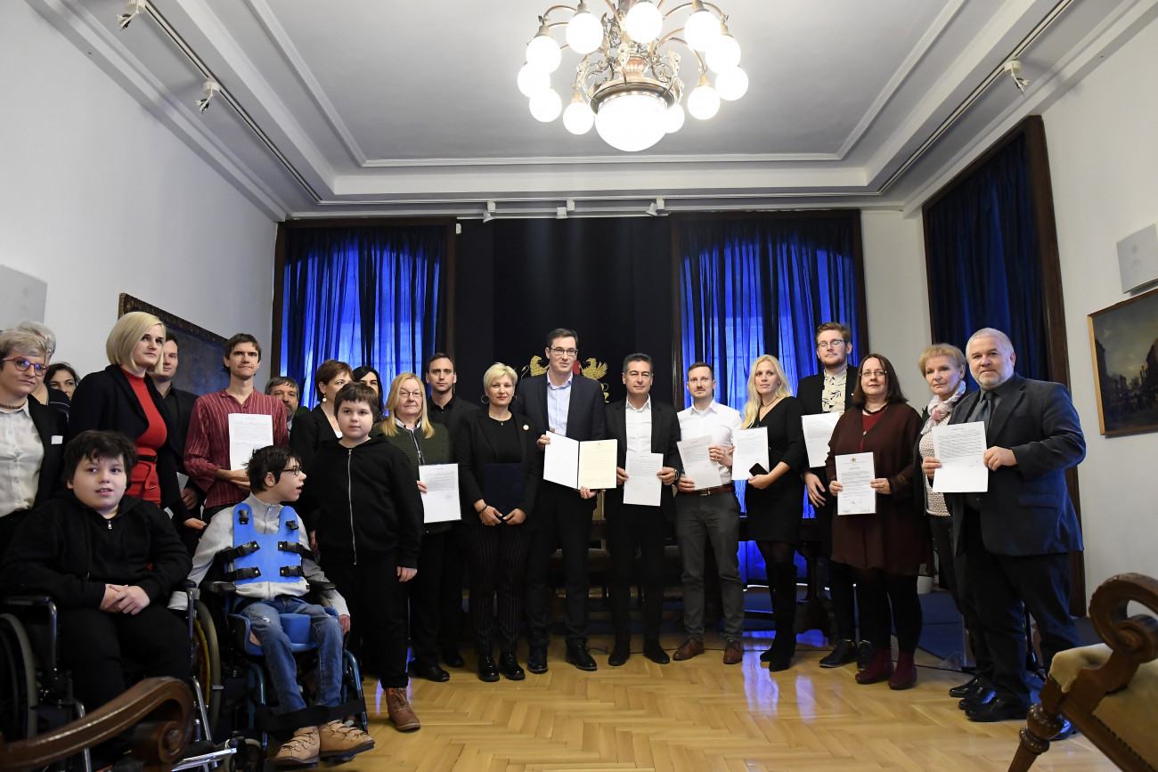 Budapest, 2019. december 3.
A részt vevő szervezetek képviselői, középen Karácsony Gergely főpolgármester (j8) és Csordás Anett, a sérült gyermeket nevelő családok érdekképviseletét ellátó Lépjünk, hogy léphessenek! Közhasznú Egyesület vezetője (j9) miután aláírták a fogyatékosügy önkormányzati támogatásáról szóló szándéknyilatkozatot a budapesti Városházán 2019. december 3-án. A szándéknyilatkozathoz tizennégy, az érintetteket képviselő civil szervezet csatlakozott. Jobbról Horváth Csaba (MSZP), Zugló polgármestere (j7).
MTI/Kovács Tamás