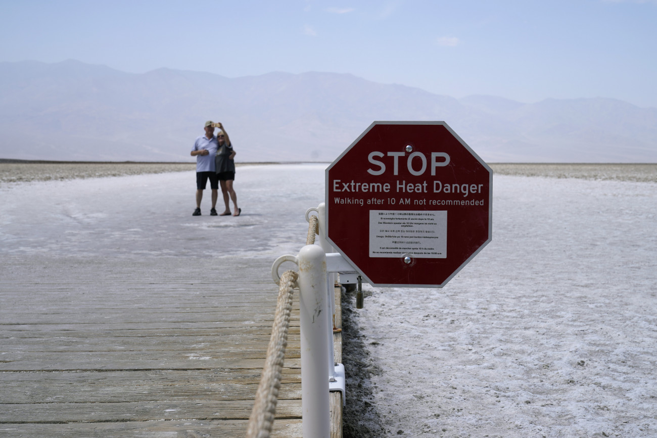 Death Valley Nemzeti Park, 2020. augusztus 18.
Fényképezkedő házaspár a szélsőségesen magas hőmérsékletre figyelmeztető táblával az előtérben a Death Valley (Halál-völgy) Nemzeti Park területén fekvő Badwater-medencében 2020. augusztus 17-én. A Nemzeti Meteorológiai Szolgálat az előző napon rekordmagasságú, 54,4 Celsius-fokos hőmérsékletet mért a területen.
MTI/AP/John Locher