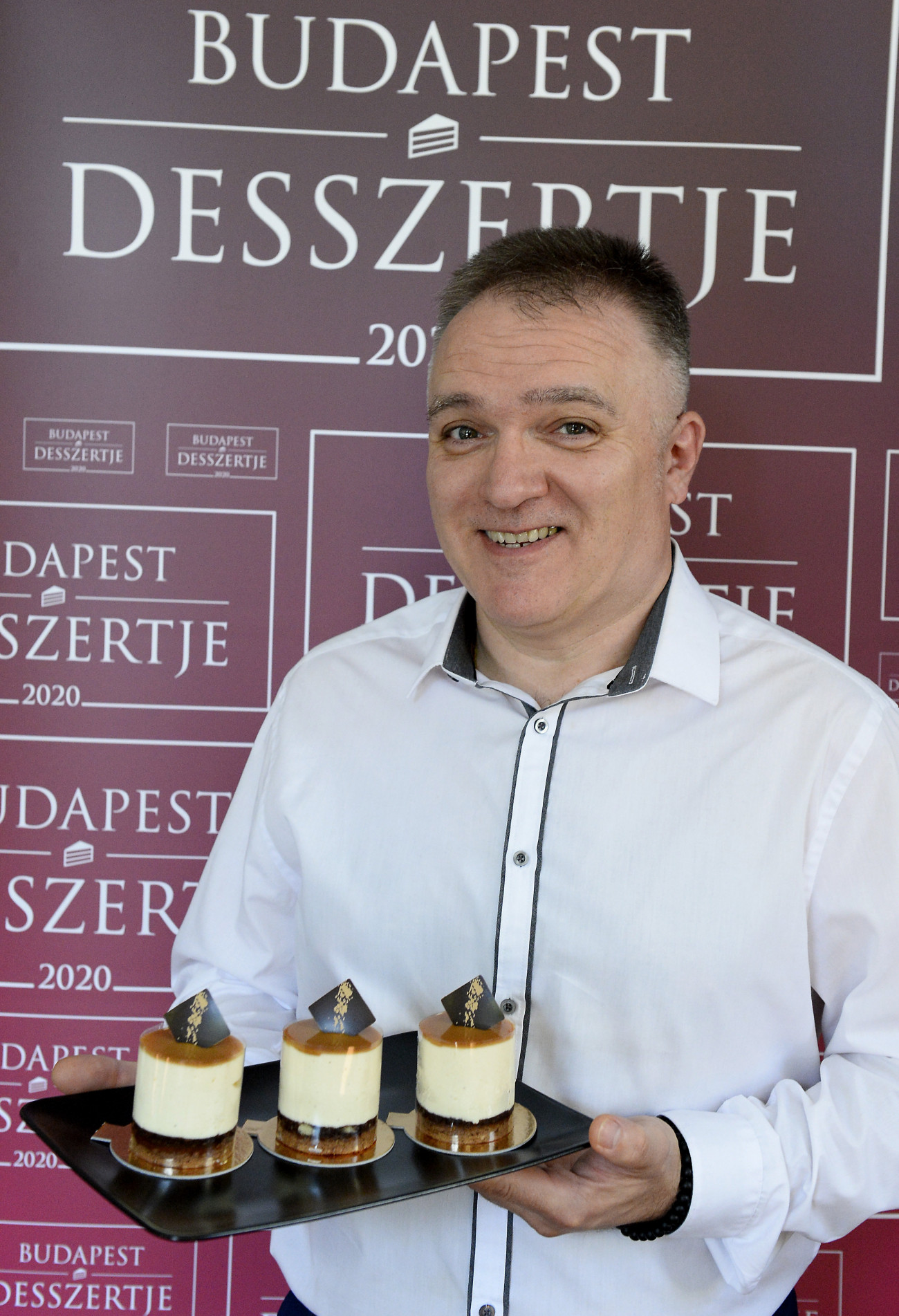 Budapest, 2020. szeptember 15.
Nagy Péter, a Szamos Marcipán cukrászmestere győztes alkotásával, a körtés karamell mousse desszerttel, a Budapest Desszertje 2020 verseny nyertes süteményével a főváros II. kerületében, a Miele bemutatóteremben 2020. szeptember 15-én. A desszert Sacher piskóta alapon vanília mousse, amelyben hideg körtepüré található, tetejére pedig karamell került. A süteményt először az idei Édes Napok Budapest csokoládé- és édességünnepen kóstolhatja meg a közönség szeptember 18. és 20. között a Szent István-bazilika előtt.
MTI/Soós Lajos