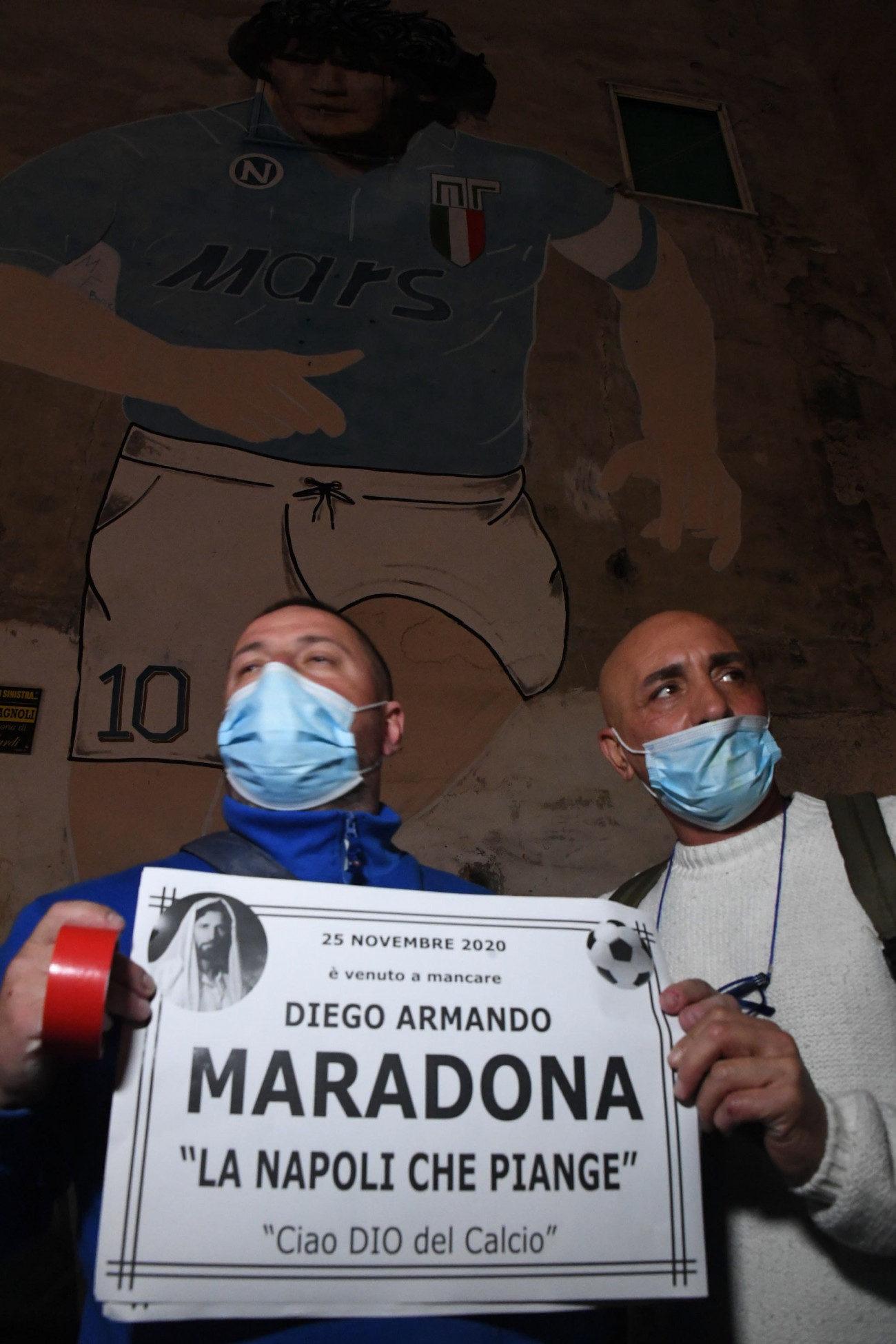 Nápoly, 2020. november 25.
Diego Maradona legendás argentin labdarúgó haláláról szóló papírlapot tart a kezében két féri Nápolyban 2020. november 25-én. Sajtóhírek szerint az elmúlt hetekben többször is kórházban kezelt Maradona 2020. november 25-én elhunyt.
MTI/EPA-ANSA/Ciro Fusco