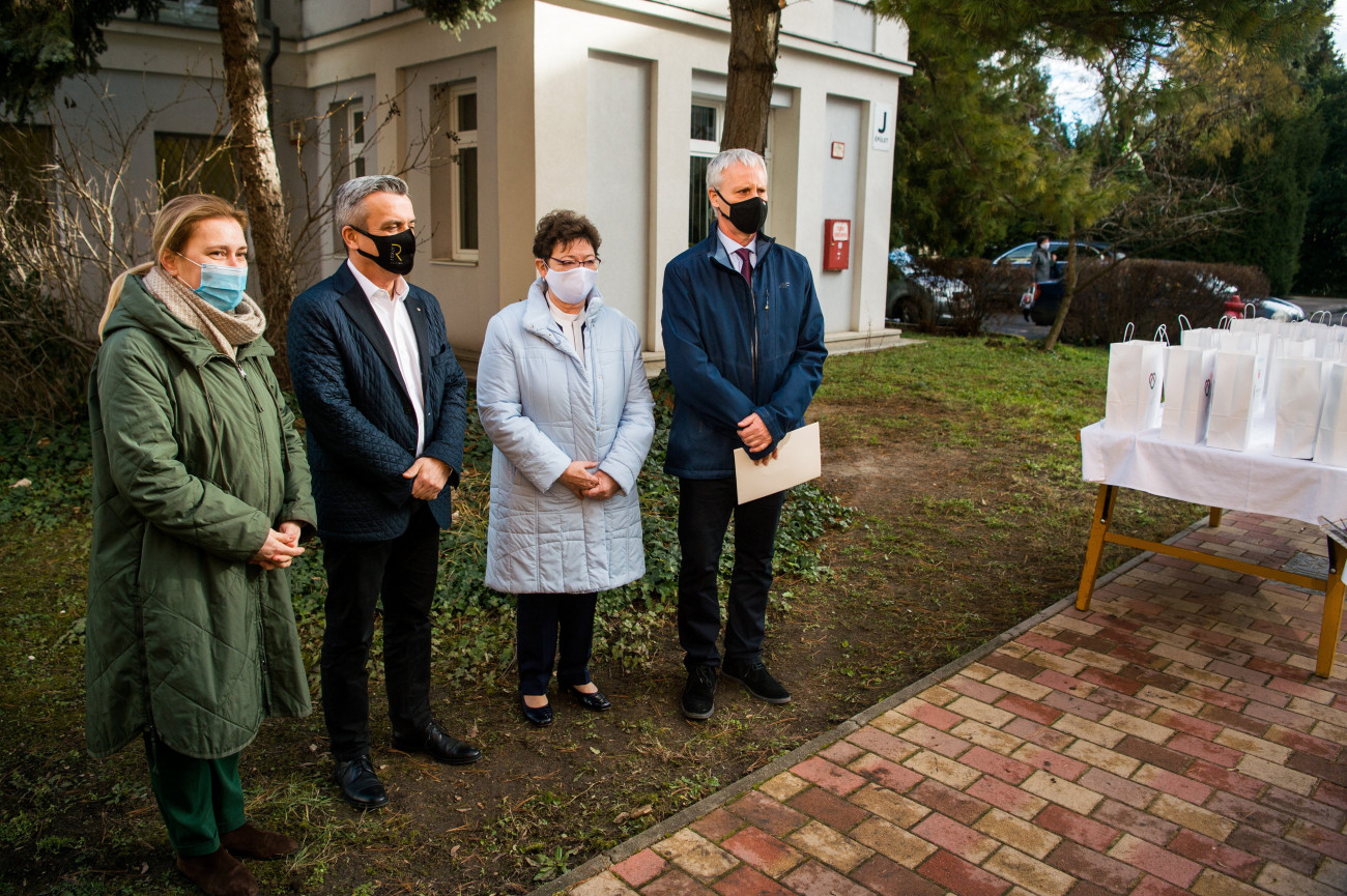 Budapest, 2021. február 4.
Auguszt Ibolya, az Auguszt Cukrászda tulajdonosa, Rókusfalvy Pál, a Borászok Borásza-díj alapítója, Müller Cecília országos tisztifőorvos és Soltész Miklós, a Miniszterelnökség egyházi és nemzetiségi kapcsolatokért felelős államtitkára, a Nemzeti Humanitárius Koordinációs Tanács (NHKT) elnöke (b-j) a magyar borászok és cukrászok felajánlásának átadásán a Nemzeti Népegészségügyi Központ udvarán 2021. február 4-én. Harminckét magyarországi borász 1200 palack bort, kilenc cukrász pedig mintegy 600 csomag süteményt ajánlott fel az NNK dolgozóinak munkájuk elismeréseként.
MTI/Balogh Zoltán