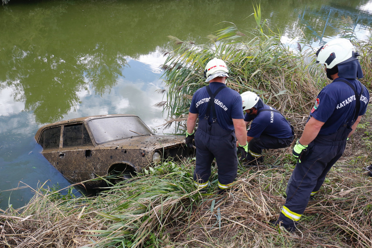 Zalavár, 2021. augusztus 31.
Tűzoltók egy autó kiemelésén a Zala folyónál Zalavár közelében 2021. augusztus 31-én. A vízből kiemelt Lada vélhetően egy az 1990-es évek vége felé ellopott autó, amiben a kiemelésekor nem találtak emberi maradványokat.
MTI/Varga György