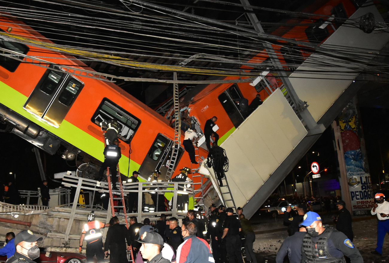 Mexikóváros, 2021. május 4.
Az áldozatok kiszabadításán dolgoznak a mentőalakulat tagjai, miután leomlott egy metróvonal utcai felüljárója és kocsik zuhantak le Mexikóvárosban 2021. május 3-án este. Legalább tizenöt ember életét vesztette, mintegy hetven megsérült.
MTI/EPA/EFE/Sáshenka Gutierrez