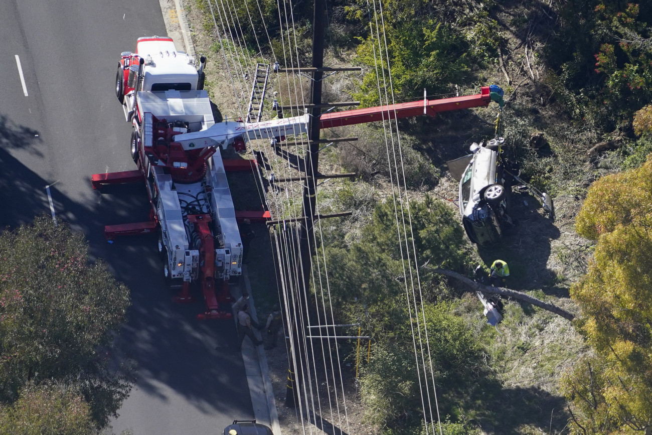 Rancho Palos Verdes, CA - February 23: Workers move a vehicle after a rollover accident involving golfer Tiger Woods on Tuesday, Feb. 23, 2021 in Rancho Palos Verdes, CA. Woods suffered leg injuries in the one-car accident and was undergoing surgery, authorities and his manager said.(Mark J. Terrill for For The Times)