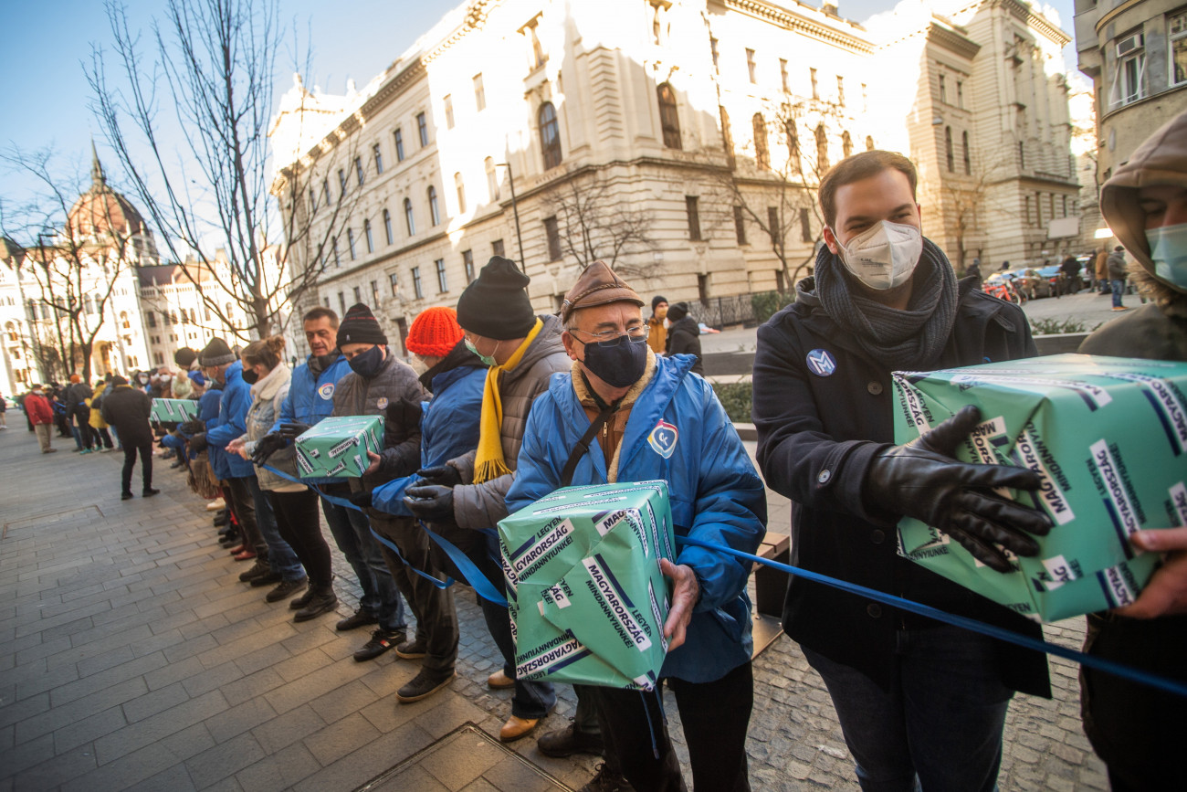 Budapest, 2022. január 21.
Aktivisták élőláncával juttatják el a Fudan Egyetemről és az álláskeresési járadékról szóló ellenzéki népszavazási kezdeményezéshez összegyűlt aláírásgyűjtő íveket az Országház előtti Kossuth Lajos térről a Nemzeti Választási Iroda Alkotmány utcai székházához 2022. január 21-én.
MTI/Balogh Zoltán