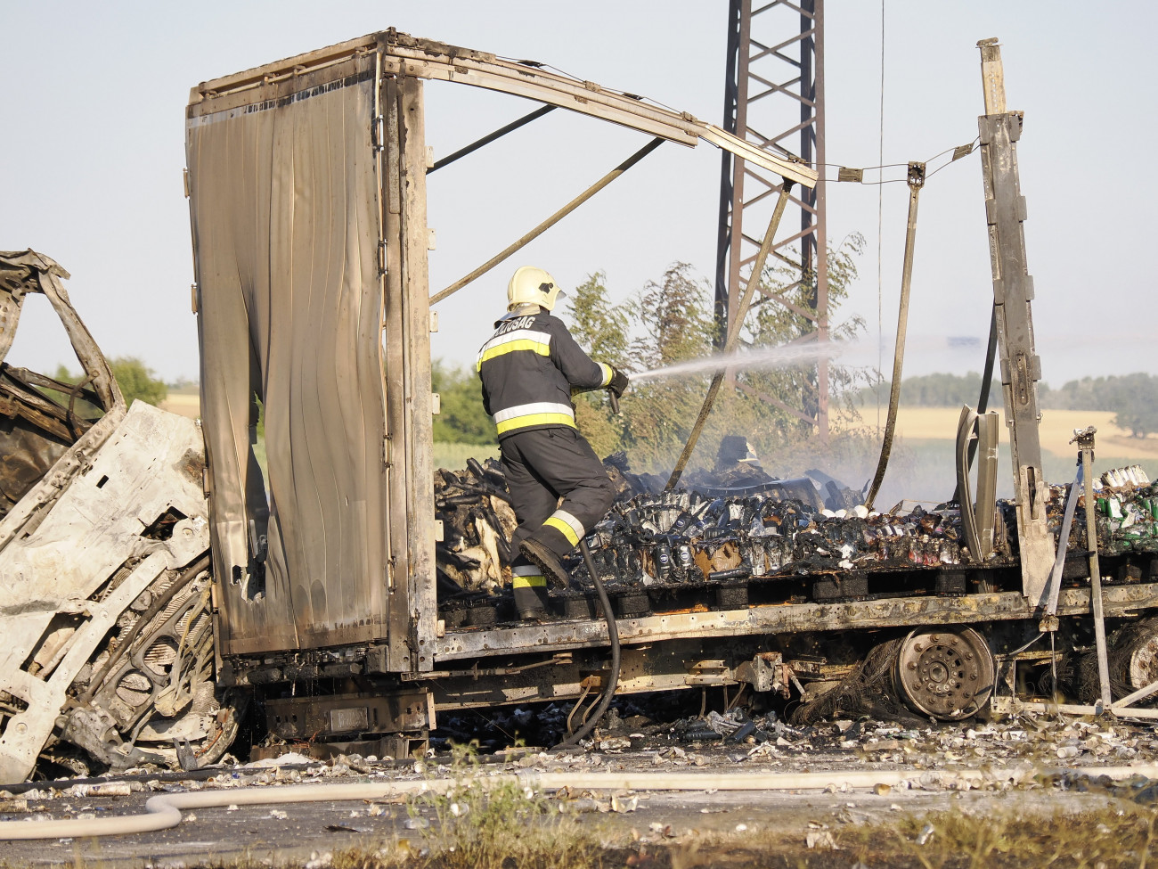 Solt, 2022. július 4.
Tűzoltó dolgozik kiégett kamionnál az 53-as főúton Solt közelében, ahol összeütközött két kamion és egy traktor 2022. július 4-én. A balesetben hárman meghaltak.
MTI/Donka Ferenc
