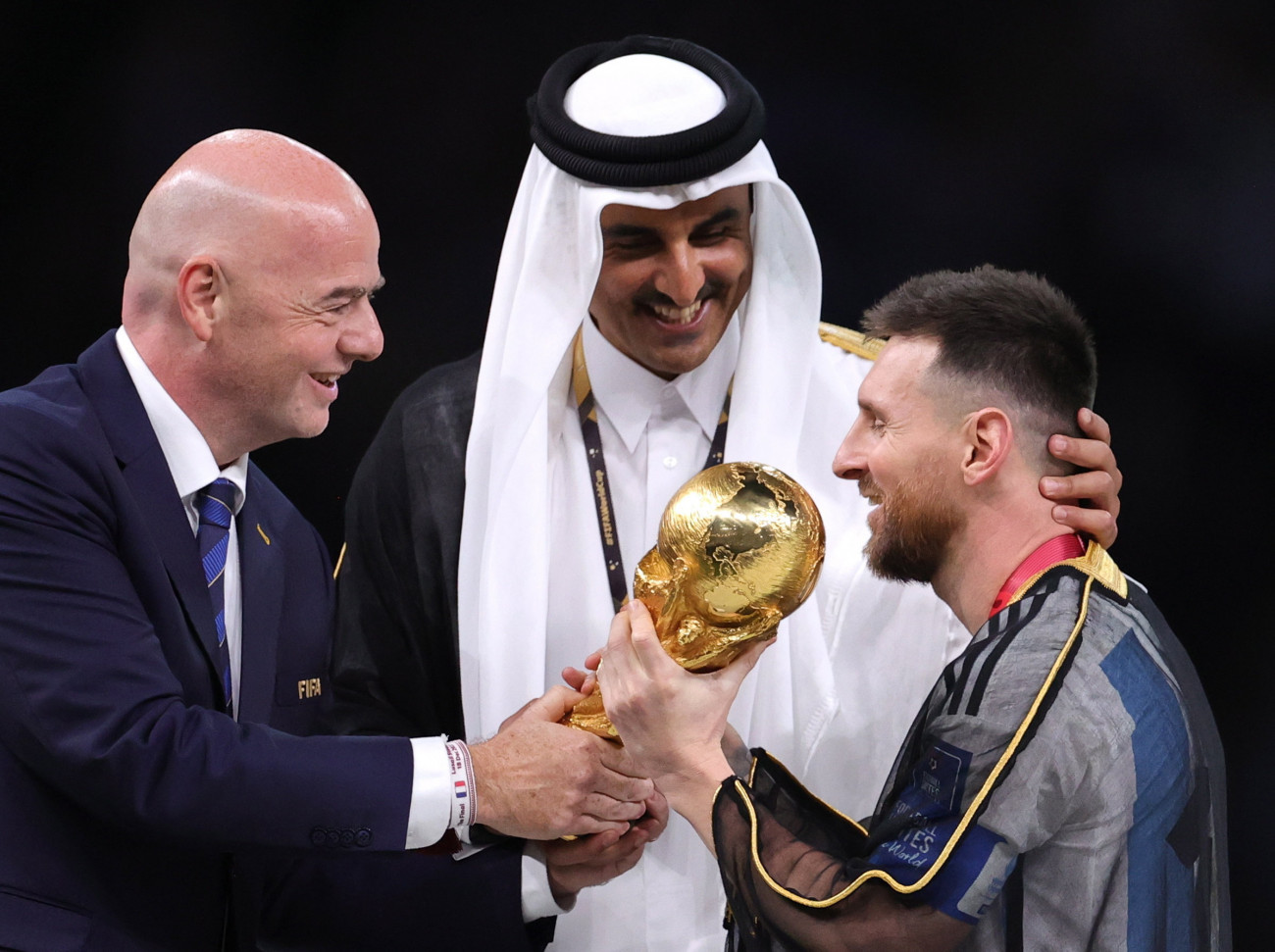 Loszaíl, 2022. december 18.
Az argentin Lionel Messi átveszi a FIFA-világkupát, a vb trófeáját Gianni Infantinótól, a Nemzetközi Labdarúgó-szövetség, a FIFA elnöktől (b) és Tamím bin Hamad ász-Száni sejktől, katari emírtől, miután csapata 4-2-re győzött a katari labdarúgó-világbajnokság döntőjében játszott Argentína-Franciaország mérkőzés 3-3-as hosszabbítása utáni tizenegyes-párbajban a Loszaíl Stadionban 2022. december 18-án.
MTI/EPA/Friedemann Vogel