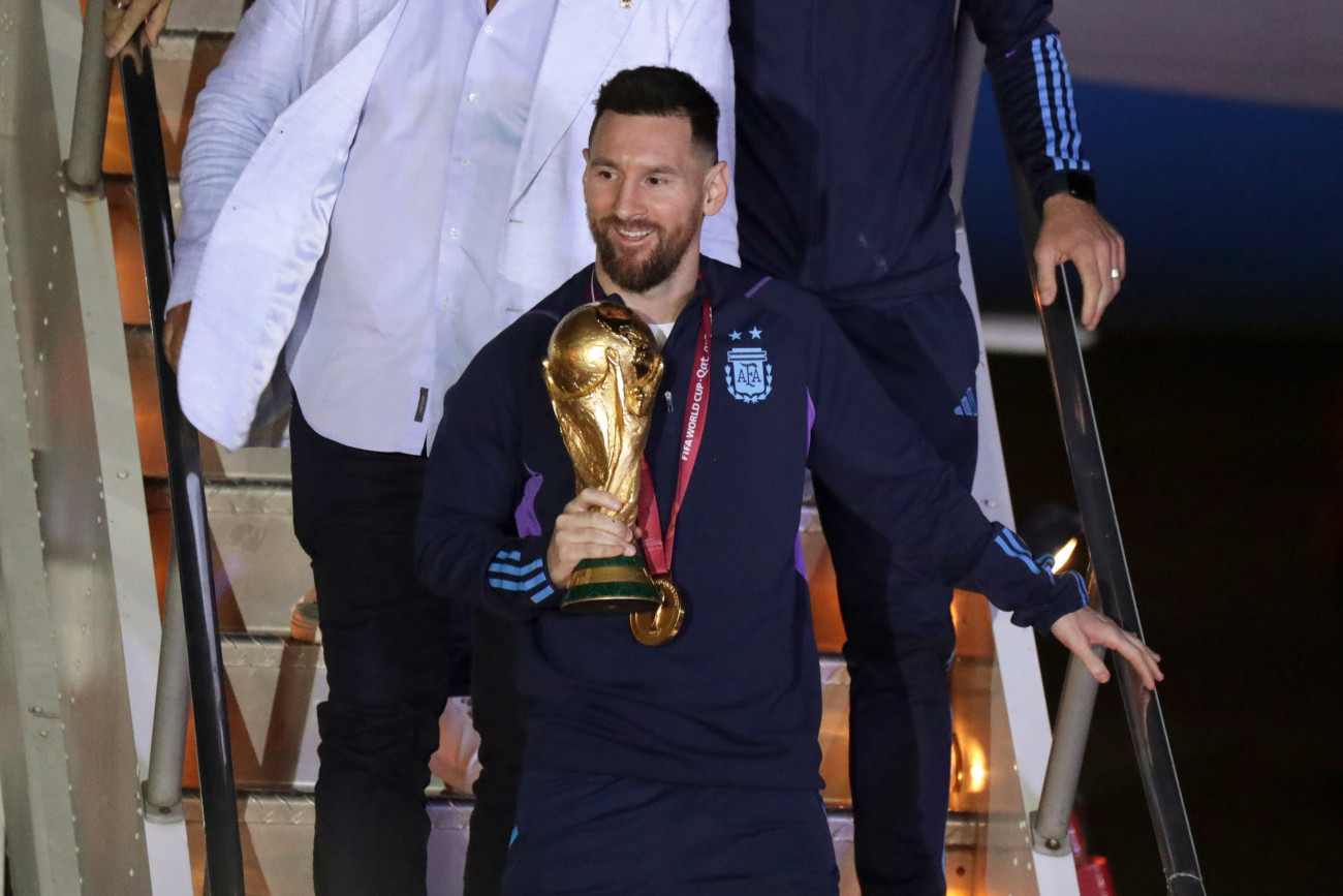 Buenos Aires, 2022. december 20.
Lionel Messi argentin csapatkapitány kezében a bajnoki trófeával, miután a válogatott játékosaival megérkezett a Buenos Aires-i Ezeiza repülőtérre 2022. december 20-án. Argentína két nappal korábban 4-2-re győzött a katari labdarúgó-világbajnokság döntőjében játszott Argentína-Franciaország mérkőzés 3-3-as hosszabbítása utáni tizenegyes-párbajban.
MTI/EPA/EFE/Raul Martinez