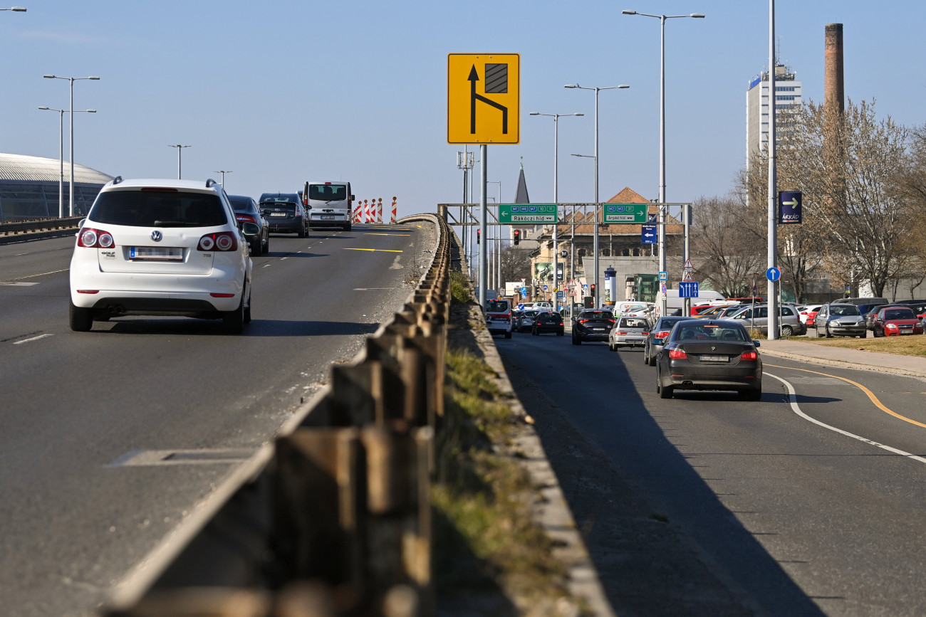 Budapest, 2023. március 4.
Forgalomelterelés sávelhúzással a népligeti felüljárón 2023. március 4-én. A híd forgalmát az állapotfelméréséhez kapcsolódó munkák miatt korlátozzák. A felmérésre azért van szükség, hogy a szakemberek pontosabb képet kapjanak az 1970-es évek végén épült felüljáró állapotáról. A több hónapon át tartó felmérés ideje alatt két gerendát kibontanak az építmény szerkezetéből, ezeket majd laboratóriumban vizsgálják meg.
MTI/Illyés Tibor