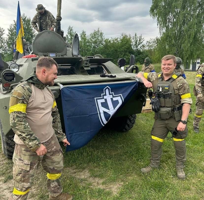 Alekszandr Szkacsov (J) a szélsőjobboldali, Orosz Önkéntes Hadtest tagjaival, egy Belgorodnál zsákmányolt, BTR-80 páncélozott szállító harcjárművel. Forrás:Twitter/Leonardo Bianchi