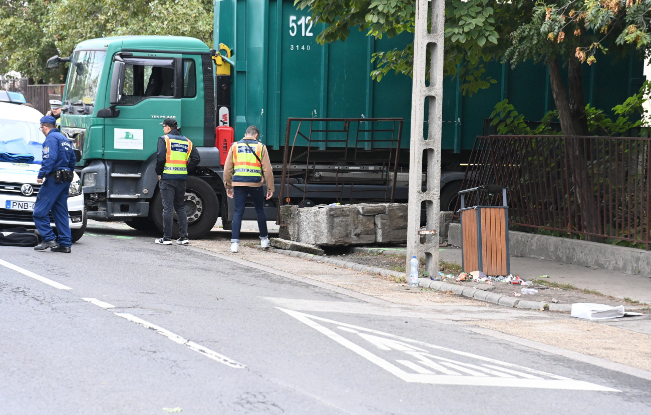 Budapest, 2023. október 10.
Rendőrök egy pesterzsébeti iskolánál, ahol egy teherautó kőkerítésnek ütközött, ami rádőlt egy 9 éves gyermekre és édesanyjára 2023. október 10-én. A fiú a helyszínen életét vesztette, édesanyja lábsérülést szenvedett, őt a traumatológiai centrumba vitték.
MTI/Mihádák Zoltán