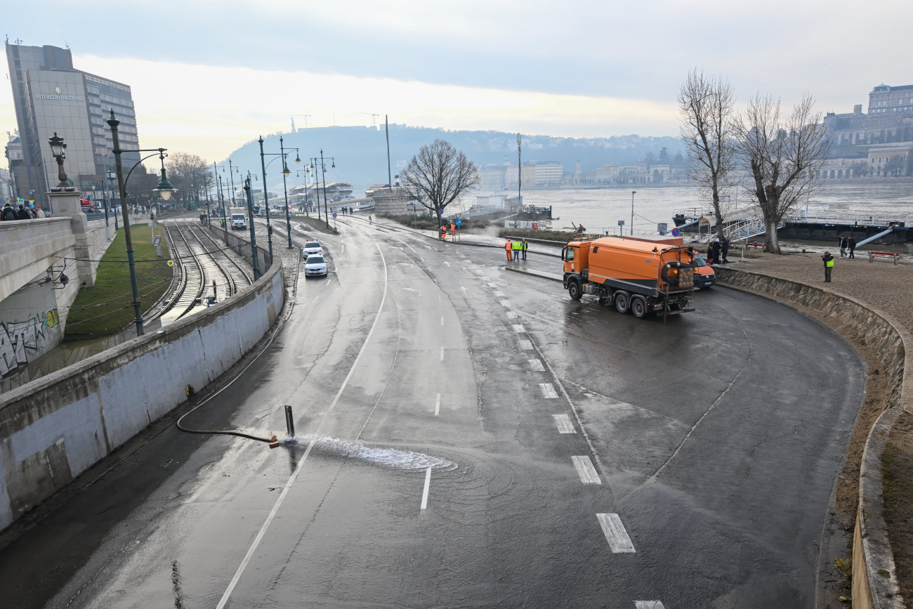 Budapest, 2023. december 30.
A Fővárosi Közterület-fenntartó Zrt. munkagépe takarítja a fővárosi idősebb Antall József rakpart Lánchíd melletti szakaszát a Széchenyi István térnél a Dunán levonuló árhullám után 2023. december 30-án. A takarítás után a Budapest Közút Zrt. eltávolítja az alsó rakpartokra való lehajtást tiltó táblákat, így várhatóan december 31-én reggeltől mindkét alsó rakparton újra megindulhat a közlekedés.
MTI/Illyés Tibor