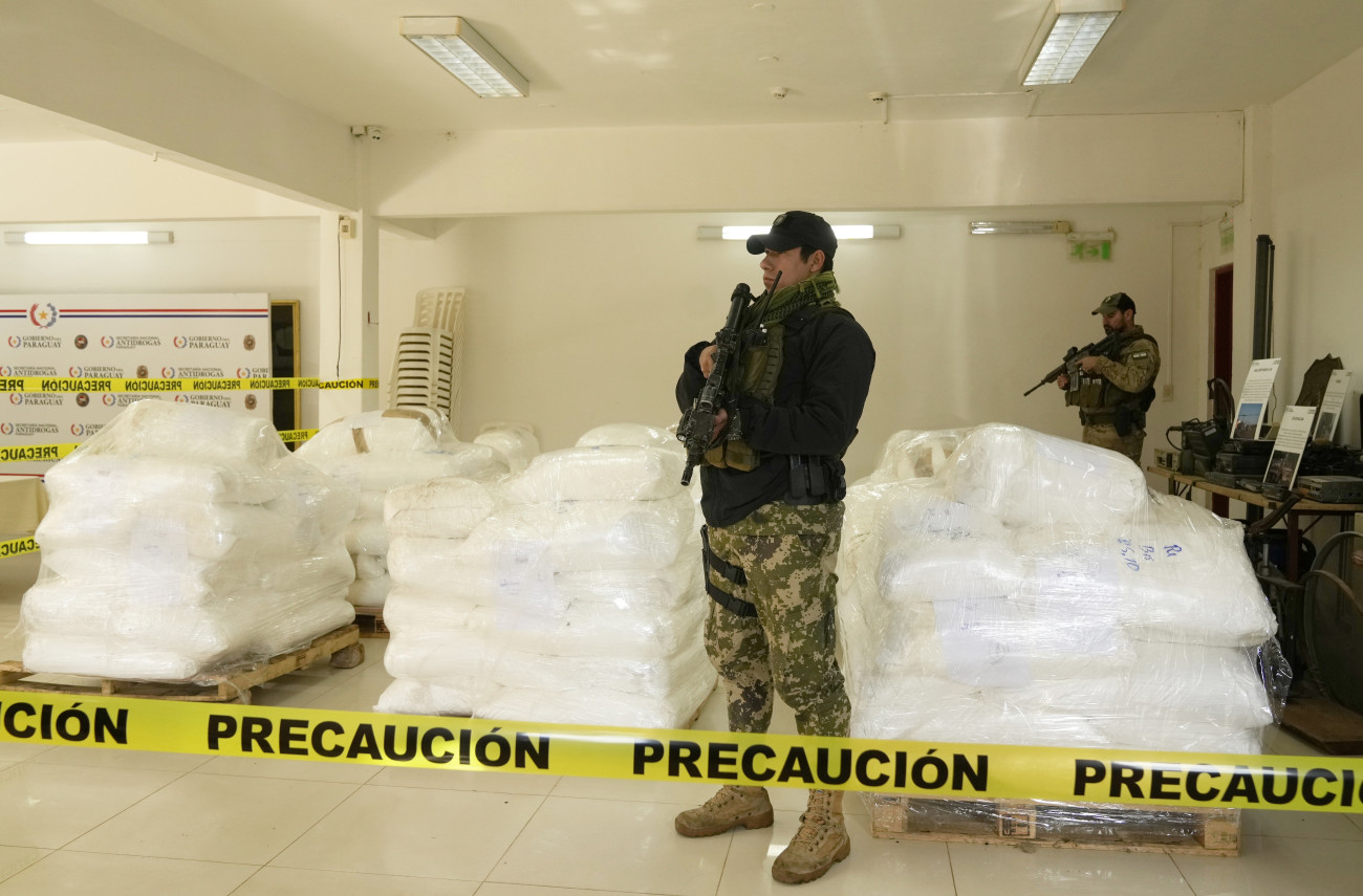 Asunción, 2024. július 16.
A paraguayi kábítószer-ellenes ügynökség rendőrei őrzik a kokaint tartalmazó zsákokat Asunción kikötőjében 2024. július 16-án. A hatóságok az ország történetének legnagyobb, négy tonnányi kokainszállítmányát foglalták le, amelyet a csempészek egy Belgiumba szánt cukorrakomány közé rejtettek.
MTI/AP/Jorge Saenz