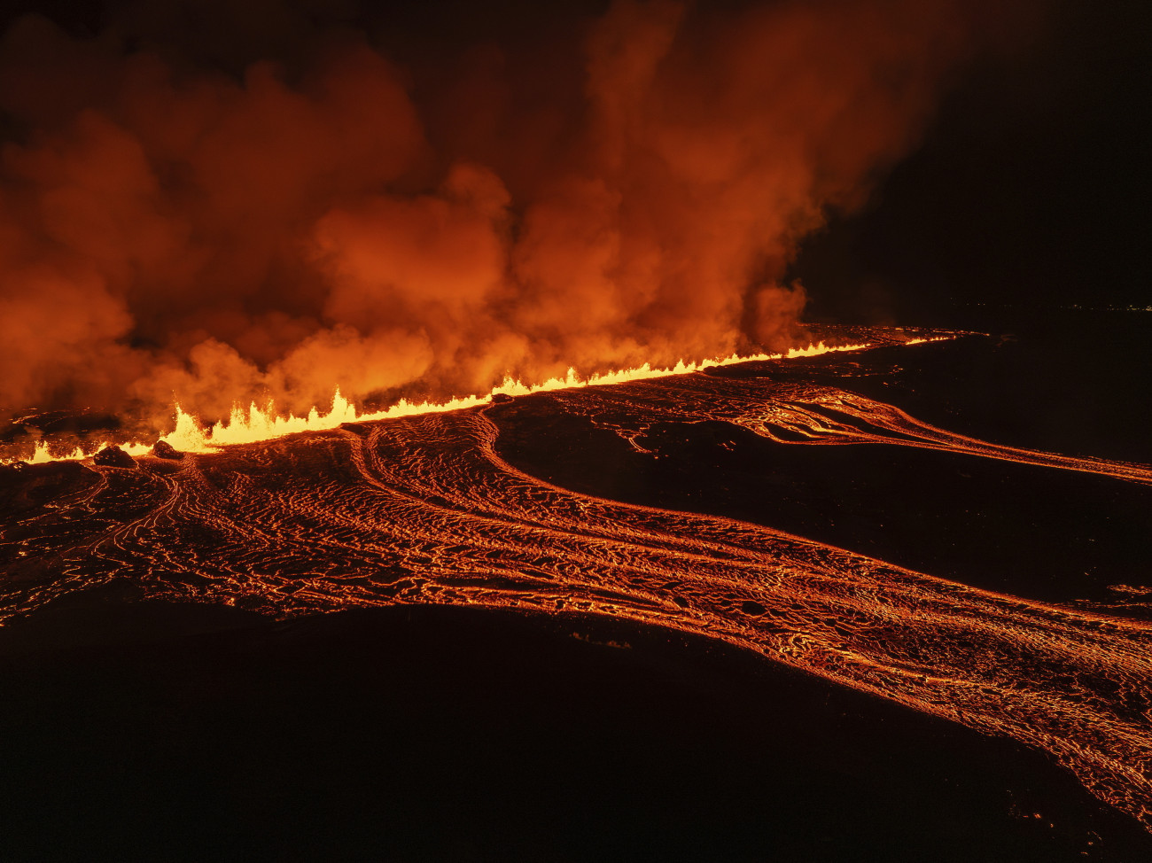 Reykjanes-félsziget, 2024. november 21.
Lávafolyam tör fel egy újabb kőzetrepedésből az izlandi Reykjanes-félszigeten 2024. november 20-án. Az utóbbi egy évben fokozódott a vulkanikus tevékenység Izland északkeleti félszigetén.
MTI/AP/Marco di Marco