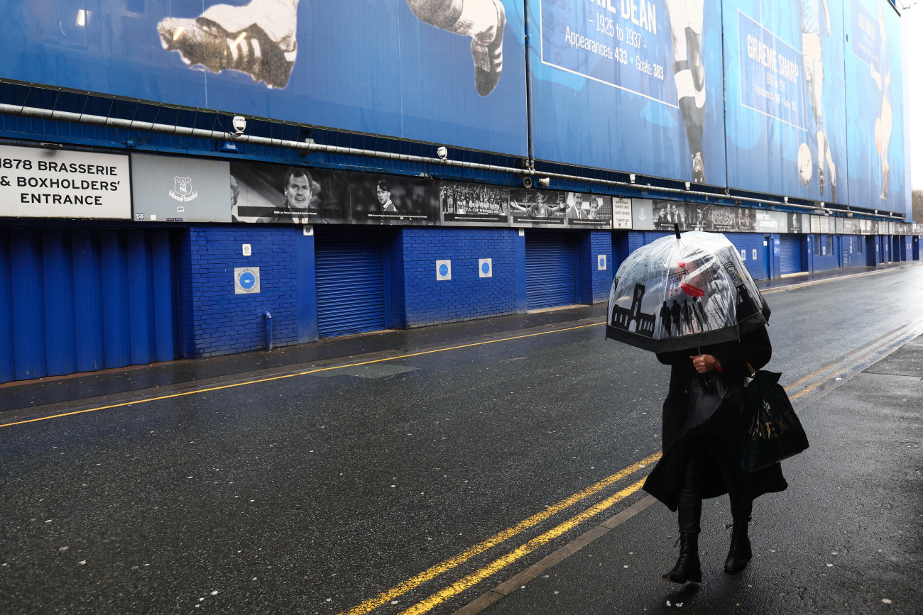 LIVERPOOL, ENGLAND - DECEMBER 7: A woman battles her way past Goodison Park with an umbrella after the game is cancelled due to Storm Darragh and poor weather ahead of during the Premier League match between Everton FC and Liverpool FC at Goodison Park on December 7, 2024 in Liverpool, England. (Photo by Charlotte Wilson/Offside/Offside via Getty Images)