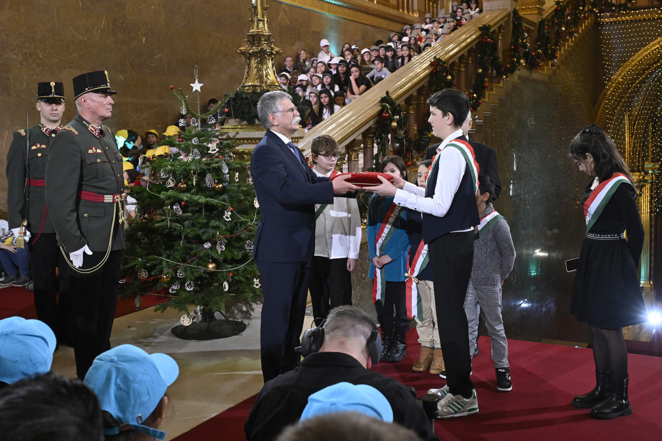 Budapest, 2024. december 21.
Kövér László, az Országgyűlés elnöke, a Nemzetközi Gyermekmentő Szolgálat (NGYSZ) Magyar Egyesületének elnöke (b) átadja az Országház kulcsát Vaszilek Áron Mihálynak, a gyermekparlament elnökének a hagyományos Országházi Gyermekkarácsony rendezvényen a Parlamentben, ahol az Országgyűlés és a Nemzetközi Gyermekmentő Szolgálat 800 hátrányos helyzetű, nehéz anyagi körülmények között élő általános iskolás gyermeket látott vendégül Magyarországról és határon túli, magyarok lakta településekről 2024. december 21-én.
MTI/Lakatos Péter