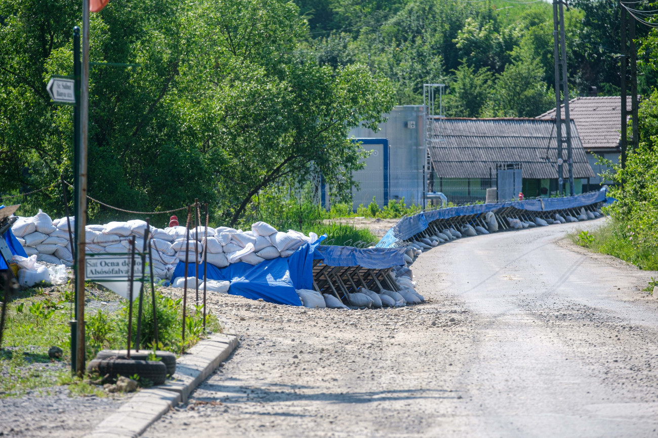 Parajd, 2025. június 8.
Mobilgátak az erdélyi Parajd községen a Bán utca kitelepített szakaszán 2025. június 8-án. A parajdi sóbányát május 6-án zárta le a katasztrófavédelem, miután a heves esőzések nyomán a Korond-patak vize betört a tárnákba. A víz néhány nap alatt teljesen elöntötte a bánya valamennyi részlegét, a légúti betegségek kezelésére és látogatók fogadására kialakított turisztikai szintet és a legújabb, Telegdy-bányát is.
MTI/Veres Nándor