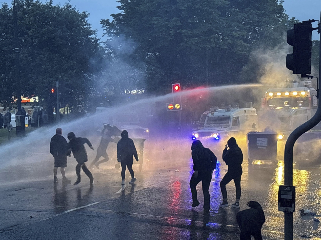 Ballymena, 2025. június 11.
Rohamrendőrök vízágyút vetnek be a tüntetők ellen az észak-írországi Ballymena városában, ahol zavargások törtek ki egy bevándorlók által elkövetett szexuális támadás miatt 2025. június 10-én. Az indulatok azt követően szabadultak el, hogy két 14 éves román bevándorló fiatal megpróbált megerőszakolni egy helyi lányt.
MTI/AP/PA/Niall Carson