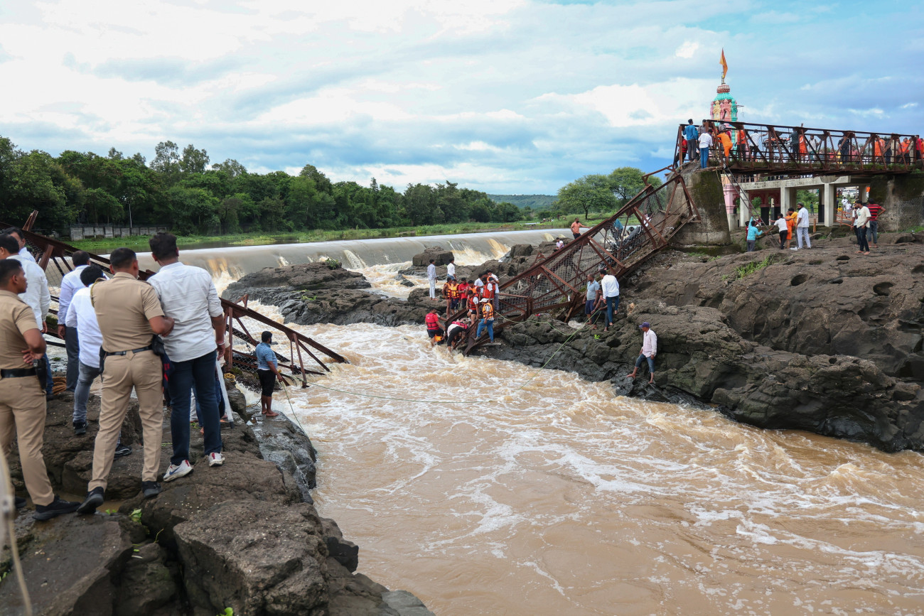 Pune, 2025. június 15.
Mentők a helyszínen 2025. június 15-én, miután leomlott egy híd az indiai Mahárástra államban fekvő Pune környékén. Legalább két ember életét vesztette, 32 megsérült, többeket elsodort az Indrajani  folyó.
MTI/EPA