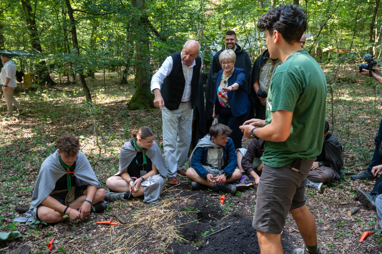 Kolozsvár, 2025. augusztus 19.
Sulyok Tamás köztársasági elnök (középen, b) és felesége, Nagy Zsuzsanna (középen, j) cserkészekkel találkozik a Romániai Magyar Cserkészszövetség (RMCSSZ) 35. jubileumi nagytáborában, a Kolozsvár melletti Lomb-erdőben az államfő háromnapos erdélyi magánlátogatásának utolsó napján, 2025. augusztus 19-én.
MTI/Kiss Gábor