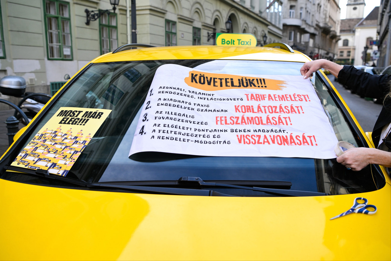Budapest, 2025. október 29.
Taxi a Fõvárosi Közgyûlés ülése alatt Városháza elõtt 2025. október 29-én. A taxisok tarifaemelést követelnek, valamint egyebek mellett szorgalmazzák az engedélyek számának korlátozását, az illegális fuvarszervezés felszámolását.
MTI/Purger Tamás