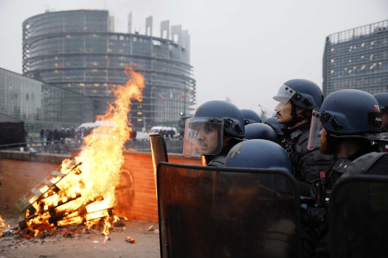 Strasbourg, 2026. január 20.
Európai gazdák összecsapnak a rendõrséggel az Európai Parlament épületénél Strasbourgban 2026. január 20-án, az EU és a dél-amerikai Mercosur szabadkereskedelmi övezet tagállamai közötti megállapodás elleni tüntetésen, az EP ülése idején. Az egyezményt három nappal korábbban írták alá Paraguayban. A tüntetésre a szakszervezetek felhívására gazdák ezrei érkeztek Franciaországból és más európai országokból több mint 700 traktorral.
MTI/EPA/Yoan Valat
