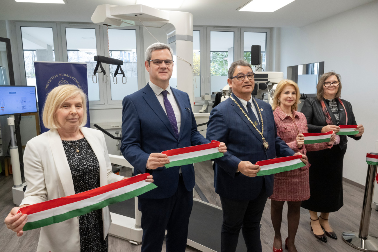 Budapest, 2026. március 24.
Feketéné Szabó Éva, a Semmelweis Egyetem stratégiai és fejlesztési rektorhelyettese, Takács Péter, a Belügyminisztérium egészségügyi államtitkára, Merkely Béla, a Semmelweis Egyetem rektora, Pavlik Lívia, a Semmelweis Egyetem kancellárja és Tenk Miklósné Zsebe Andrea, az egyetem Petõ András Karának dékánja (b-j) a Semmelweis Egyetem Petõ András Kar Konduktív Pedagógiai Központjának eszközátadó rendezvényén 2026. március 24-én. Hét egységbõl álló robotikus eszközparkot adtak át a terápiás központban. A mozgáskoordinációs, izomerõsítõ és mobilitást fejlesztõ gépeket az egyetem saját forrásból vásárolta.
MTI/Kovács Márton