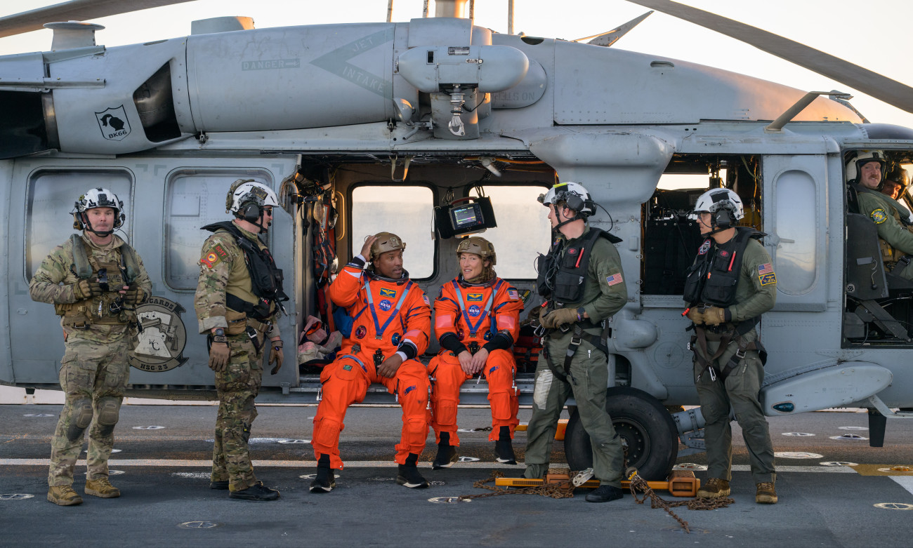 AT SEA - APRIL 10: (EDITORâS NOTE: This Handout image was provided by a third-party organization and may not adhere to Getty Imagesâ editorial policy.) In this handout photo provided by NASA, NASA astronaut Victor Glover, Artemis II pilot, left, and NASA astronaut Christina Koch, Artemis II mission specialist are seen sitting on a Navy MH-60 Seahawk from Helicopter Sea Combat Squadron (HSC) 23 on the flight deck of USS John P. Murtha after they and fellow crewmates CSA (Canadian Space Agency) astronaut Jeremy Hansen, Artemis II mission specialist, and NASA astronaut Reid Wiseman, Artemis II commander, were extracted from their Orion spacecraft after splashdown, Friday, April 10, 2026, in the Pacific Ocean off the coast of California. NASA's Artemis II mission took the quartet on a nearly 10-day journey around the Moon and back to Earth. Following a splashdown at 5:07 p.m. PDT (8:07 p.m. EDT), NASA, U.S. Navy, and U.S. Air Force teams are working to bring the Orion spacecraft aboard the recovery ship. (Pho