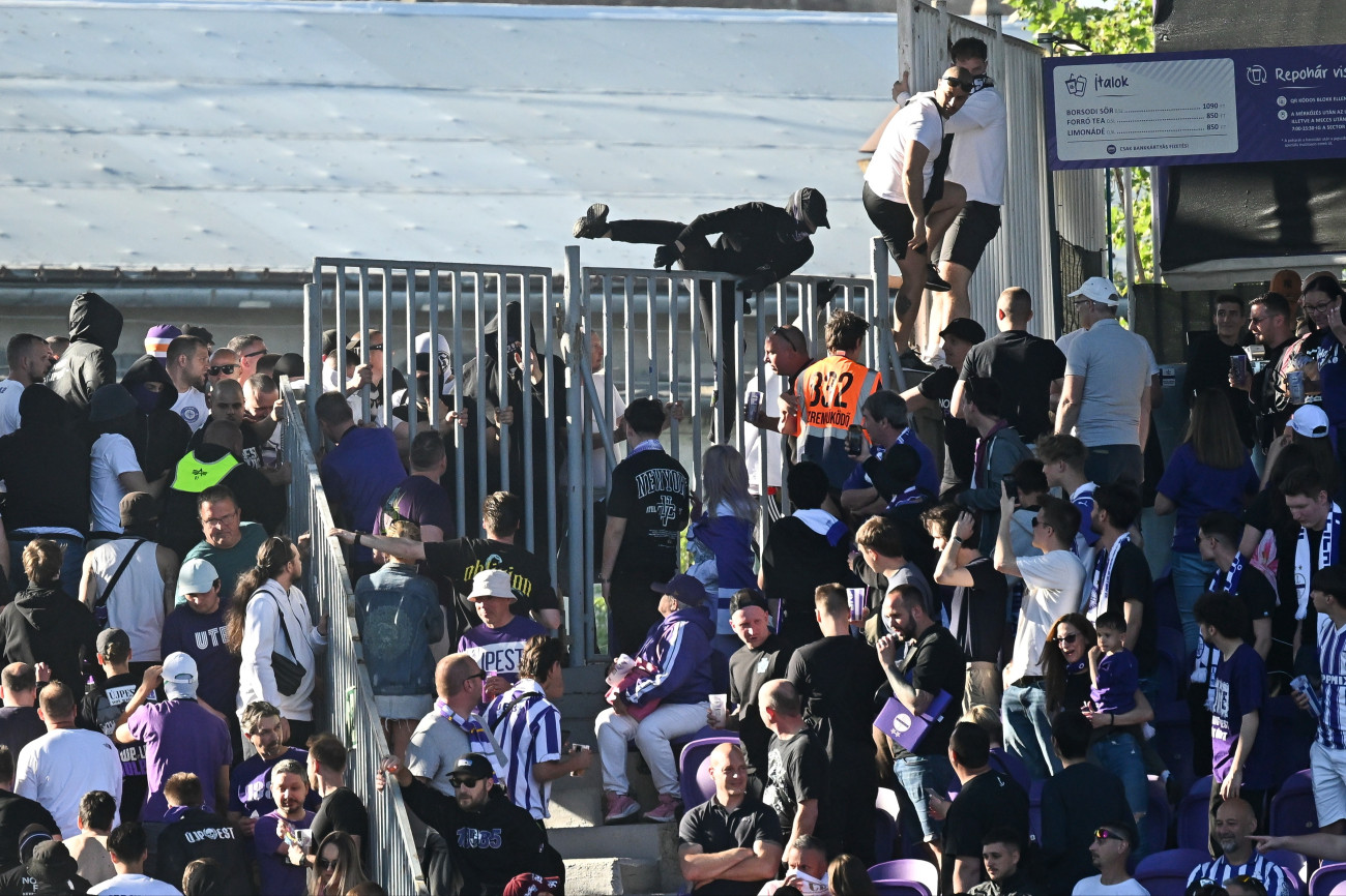 Budapest, 2026. május 3.
Az Újpest szurkolói a labdarúgó Fizz Liga 32. fordulójában játszott Újpest FC - Ferencvárosi TC mérkõzésen a Szusza Ferenc Stadionban 2026. május 3-án. A Ferencváros négygólos elõnye után a hazai szurkolók egy része átvonult a vendégszektor mellé, rendõrök is érkeztek a lelátóra, a játékvezetõ pedig bõ tíz percre félbeszakította a mérkõzést. A Ferencváros 5-0-ra gyõzött.
MTI/Hegedüs Róbert