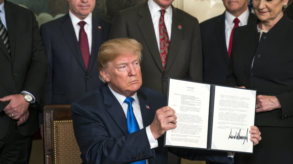 Washington, 2018. március 22.Donald Trump amerikai elnök mutatja az aláírásával ellátott, kínai importtermékekre kivetendő vámról szóló rendeletét a washingtoni Fehér Házban 2018. március 22-én. (MTI/EPA/Jim Lo Scalzo)