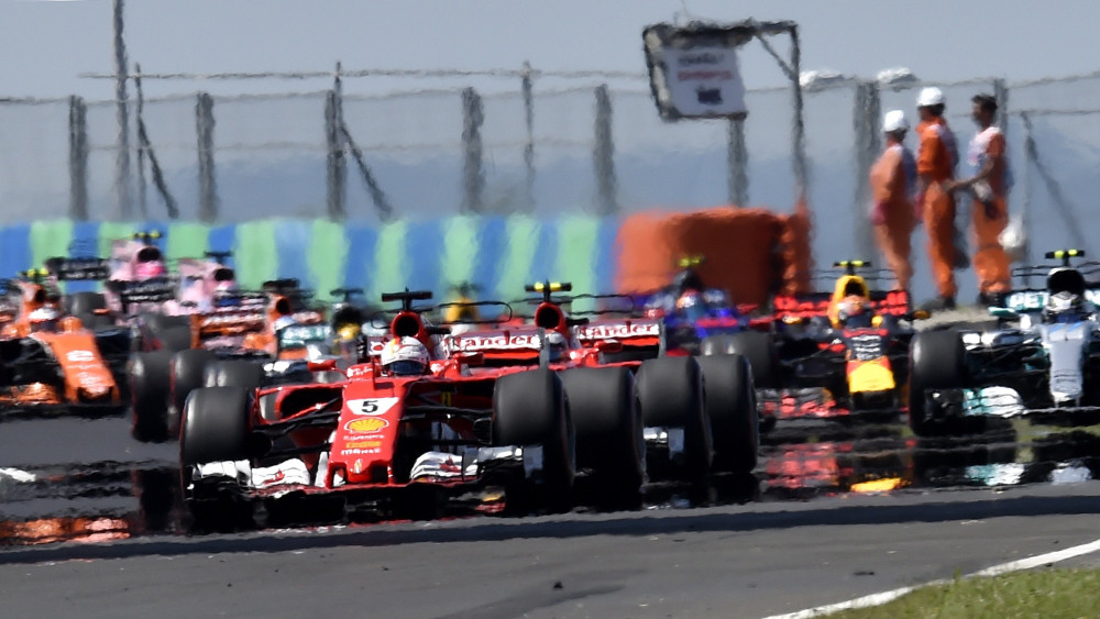 A rajt utáni első körben elöl a későbbi győztes Sebastian Vettel, a Ferrari német versenyzője a Forma-1-es Magyar Nagydíj futamán a mogyoródi Hungaroringen 2017. július 30-án.
