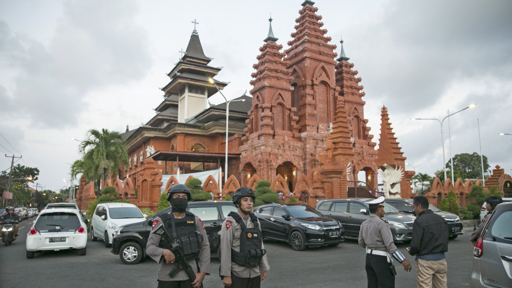 Denpasar, 2018. május 13.Indonéz rendőrök biztosítja Szentlélek-székesegyházat mise idején a Bali-szigeti Denpasarban 2018. május 13-án, miután a reggeli órákban öngyilkos merénylők robbantottak három keresztény templomban a kelet-jávai Surabaya városban. A támadások elkövetője valószínűleg az Iszlám Állam dzsihadista terrorszervezethez kötődő Jamaah Ansharut Daulah nevű indonéziai szélsőséges csoport. (MTI/EPA/Made Nagi)