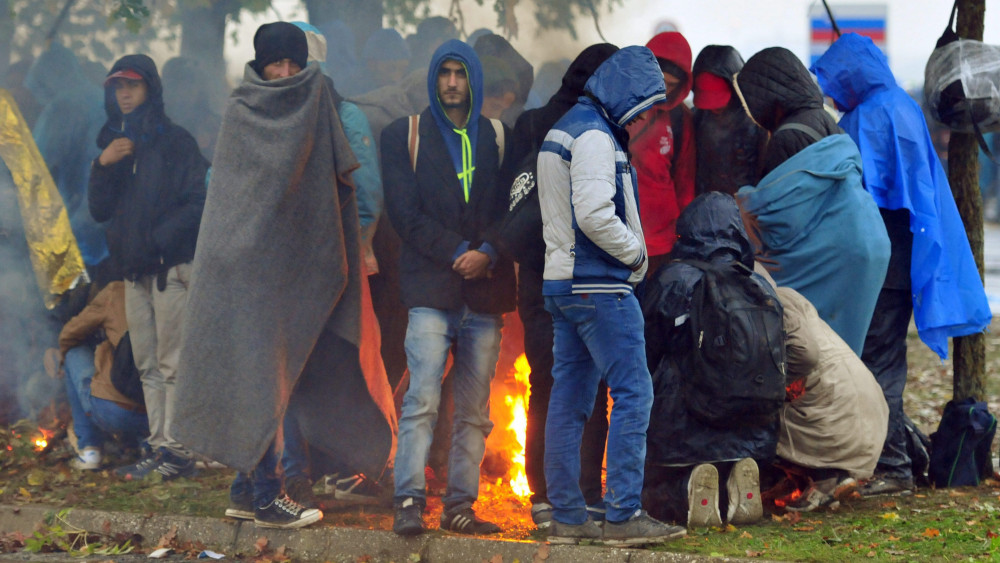 Drávamagyaród, 2015. október 19.Migránsok melegednek egy tábortűznél az esőben a horvát-szlovén határ mentén fekvő Drávamagyaródon (Trnovec) 2015. október 19-én. (MTI/EPA/Igor Kupljenik)