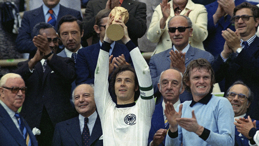 West Germanys national football team captain, Franz Beckenbauer, holds up the World Cup trophy after they defeated the Netherlands 2-1 in the World Cup soccer final on July 7, 1974, at Munichs Olympic stadium in Germany. Applauding at right, German goalkeeper Josef Sepp Maier and from left: FIFA president Sir Stanley Rous and German president Walter Scheel, smiling. (AP Photo)
