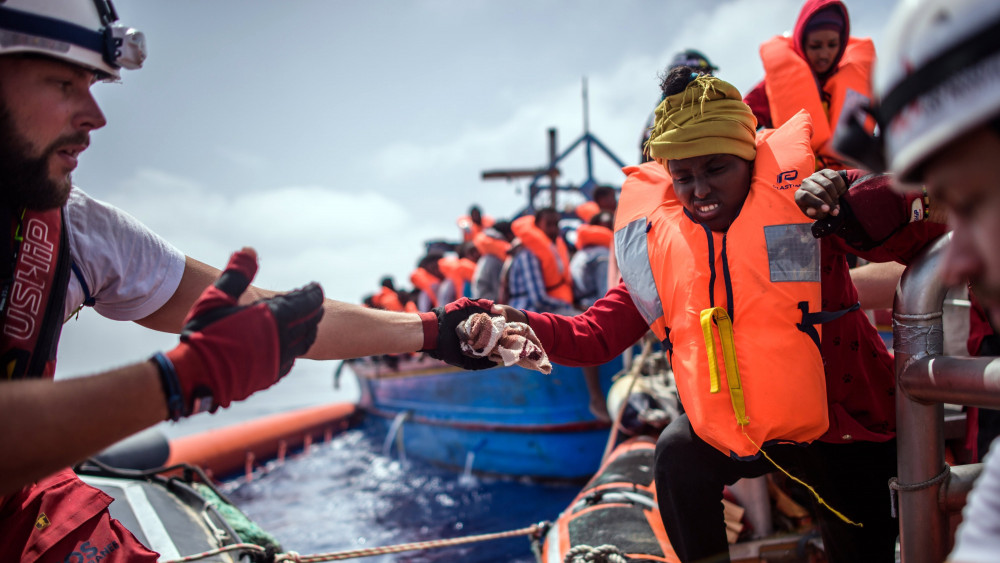 Földközi-tenger, 2018. április 21.Afrikai migránsnak segítenek gumicsónakba szállni az illegális bevándorlók tengeri mentését végző SOS Mediterranee civil szervezet Aquarius nevű hajója legénységének tagjai a Földközi-tengeren 2018. április 21-én. Az Aquarius mintegy 250 csónakban utazó illegális bevándorlót vett a fedélzetére a líbiai partoktól mintegy 50 kilométerre. (MTI/EPA/Christophe Petit Tesson)