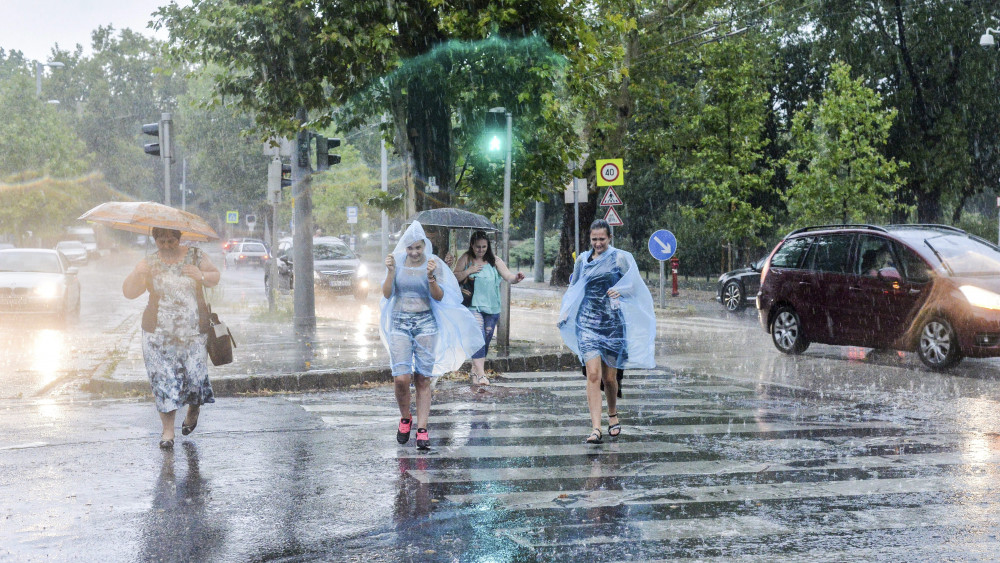 Gyalogosok futnak át az úttesten az esőben Budapesten, az Állatkerti sétányon 2017. augusztus 6-án.