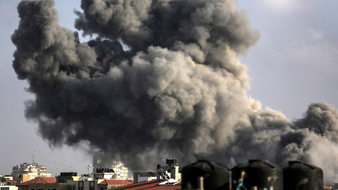 Gáza, 2018. július 14.Füst tör elő egy épületből egy izraeli rakéta becsapódása után Gázában 2018. július 14-én. Az izraeli légierő csapásokat mért a Hamász palesztin szélsőséges szervezet katonai létesítményeire a Gázai övezetben, válaszul a gázai-izraeli határ közelében történt előző napi rendbontásokra. A Gázai övezetet uraló radikális iszlamista Hamász  szervezet éjjel óta több mint száz rakétát lőtt ki Izraelre. (MTI/EPA/Haitham Imad)