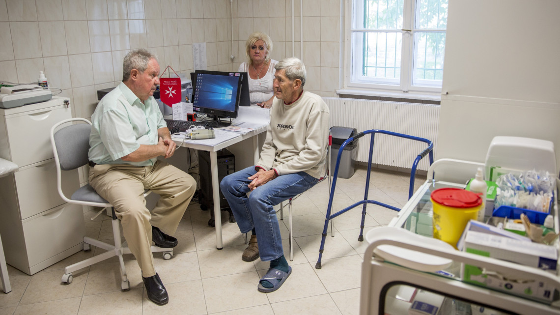Csiszár Elős orvos egy beteggel beszélget a Magyar Máltai Szeretetszolgálat dél-alföldi régiójában működő Hajléktalan Egészségügyi Centrum orvosi rendelőjében Szegeden 2018. július 17-én, a centrum ünnepélyes átadása napján.