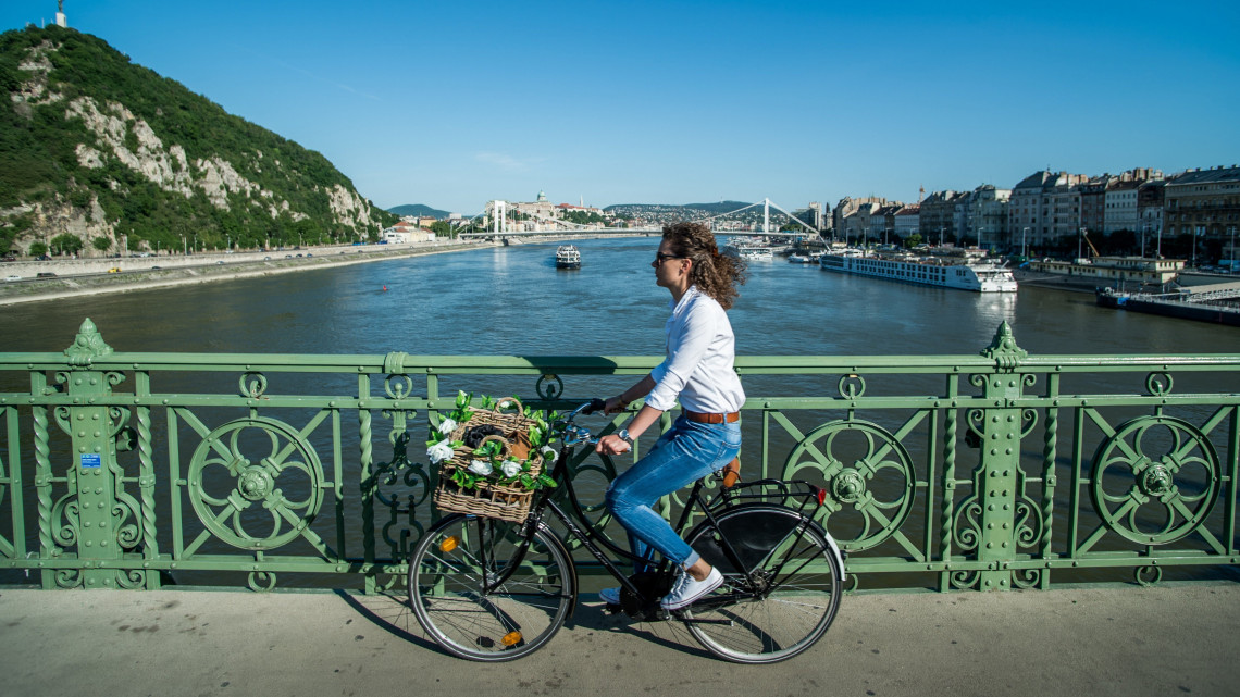 Kószó Rita projektmenedzser munkahelyére tart kerékpárjával a fővárosi Szabadság hídon 2018. május 7-én. A Magyar Kerékpárosklub május 14-től június 10-ig tartja a Bringázz a munkába! kampányt a Nemzeti Fejlesztési Minisztérium támogatásával.