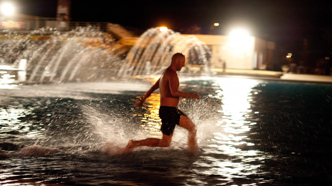 Fiatal férfi fut a vízben a strandok éjszakáján a budapesti Palatinus strandon 2012. augusztus 10-én. Közel 40 magyarországi gyógy-, élmény- és strandfürdő várta a látogatókat ezen az estén.