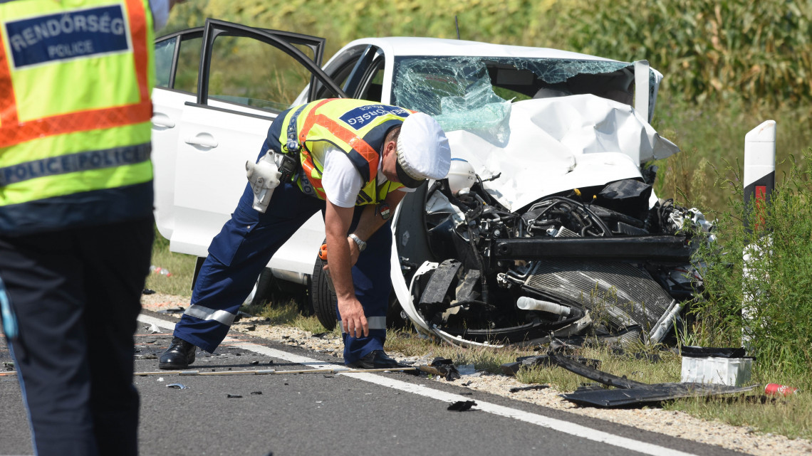 Rendőrök helyszínelnek egy összetört személygépkocsinál a 4-es főút 95-ös kilométerénél, Szolnoknál, ahol két autó frontálisan összeütközött 2018. augusztus 3-án. A balesetben egy ember meghalt, öten súlyosan, illetve életveszélyesen megsérültek.