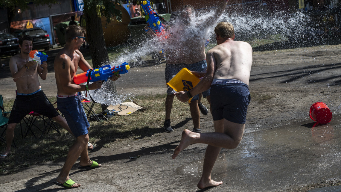 Fesztiválozók locsolják egymást a 26. Sziget fesztivál kezdete előtti napon az óbudai Hajógyári-szigeten 2018. augusztus 7-én. Mintegy tízezer ember van már a Szigeten. Az idén augusztus 8. és 15. között rendezik meg az egyhetes fesztivált.