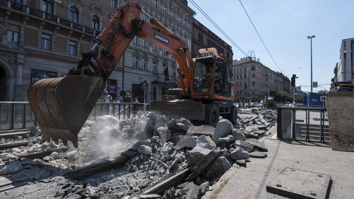 Munkagép a 4-es és 6-os villamos Blaha Lujza téri szakaszának felújításán 2018. július 5-én. Az Oktogon és a Harminckettesek tere között pályafelújítást végeznek, ezért pótlóbuszok szállítják az utasokat az Oktogon és a Corvin-negyed között.