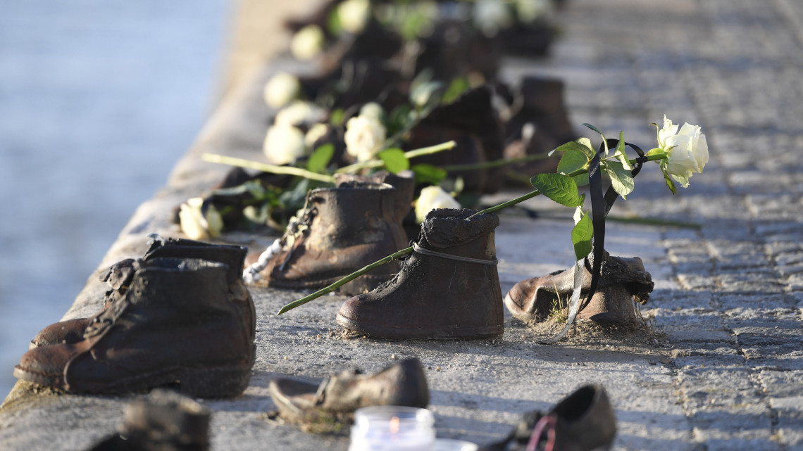 A totalitárius diktatúrák áldozatainak európai emléknapján rendezett emlékmenet résztvevői által elhelyezett virágok a Cipők a Duna-parton emlékműnél 2017. augusztus 23-án.
