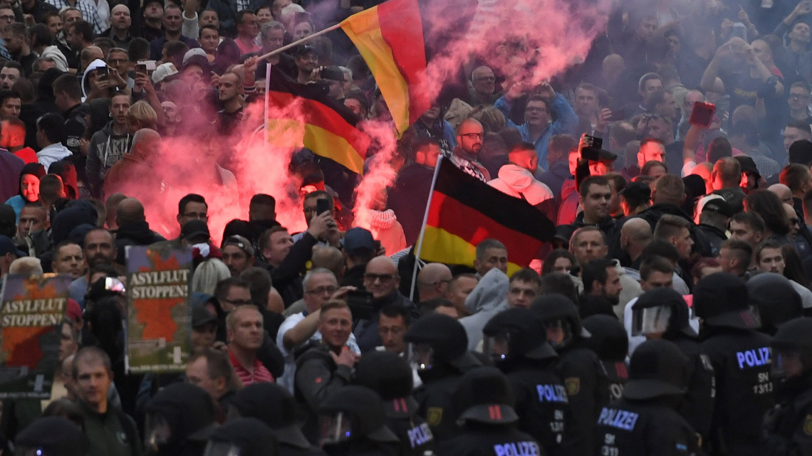 Chemnitz, 2018. augusztus 27.Szélsőjobboldali tüntetők és rendőrök a kelet-németországi Chemnitzben két nappal ezelőtt történt gyilkosság miatti tiltakozáson 2018. augusztus 27-én. A chemnitzi rendőrség és az ügyészség korábban arról tájékoztatott, hogy a belvárosban tartott szabadtéri fesztivál szombati programjai után, éjjel összetűzésbe keveredett egy csoport különböző nemzetiségű férfi. Egy ember életét vesztette, ketten súlyos sebesüléseket szenvedtek. Az emberöléssel egy 23 éves szíriai és egy 22 éves iraki állampolgárt gyanúsítanak. (MTI/EPA/Filip Singer)